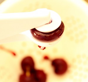 cherry pitting Chocolate-Cherry Brownies with a Choclate-Cherry Sauce #glutenfree #grainfree #dairyfree www.agutsygirl.com